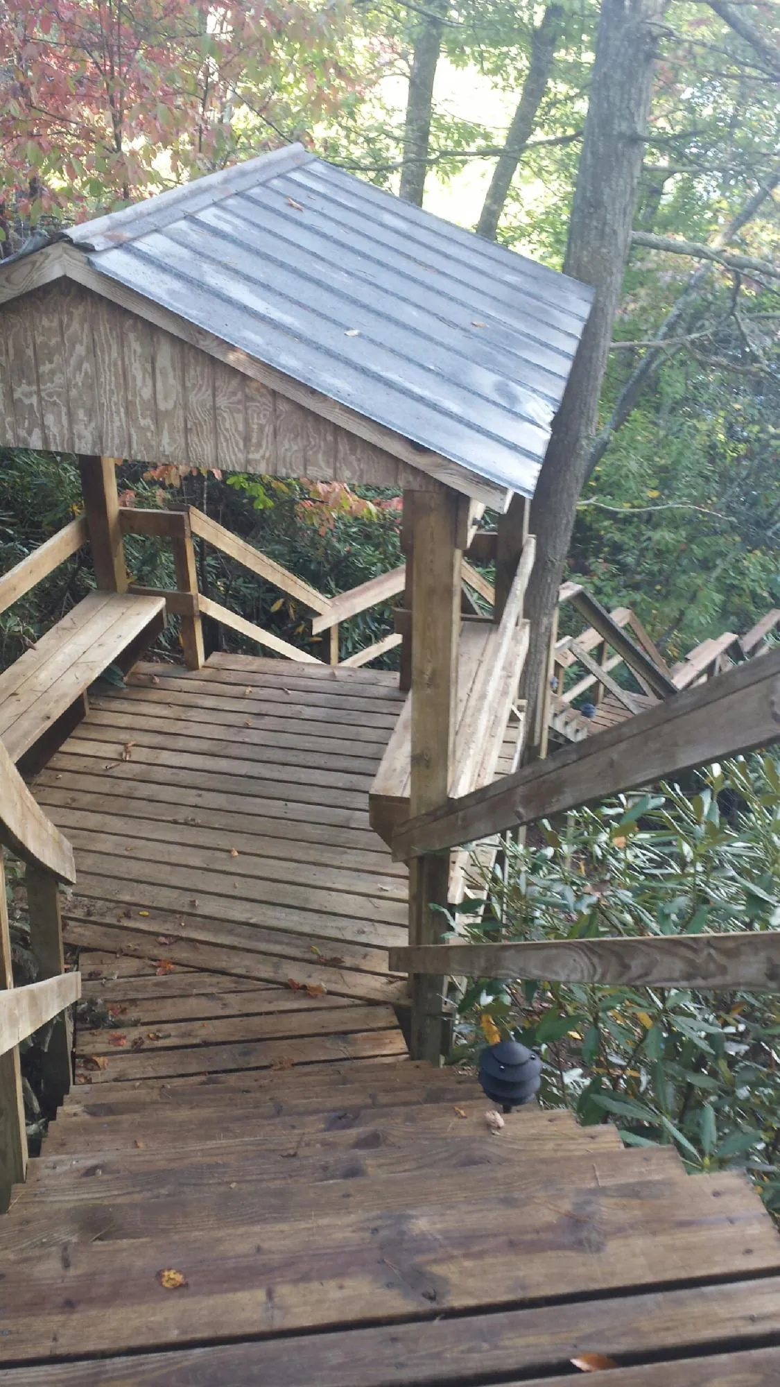 Metal roofed shelter over wooden steps on a wooded walkway — Skylight Repair & Installation work by our crew in Kerrville