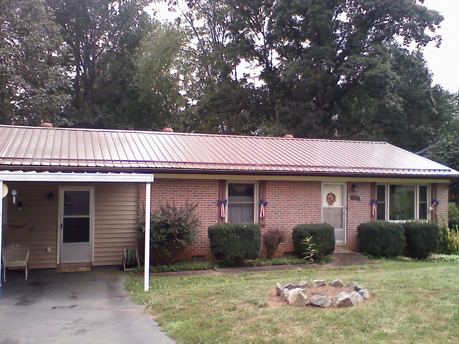 Bronze metal roof and carport on a brick ranch home — Roof Repair work by our crew in Kerrville