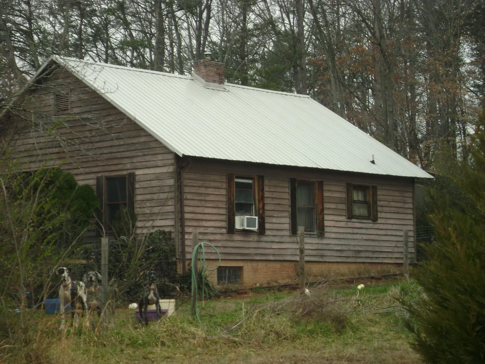 White metal roof on an old wood sided farmhouse, from a Metal Roof Installation job in Kerrville